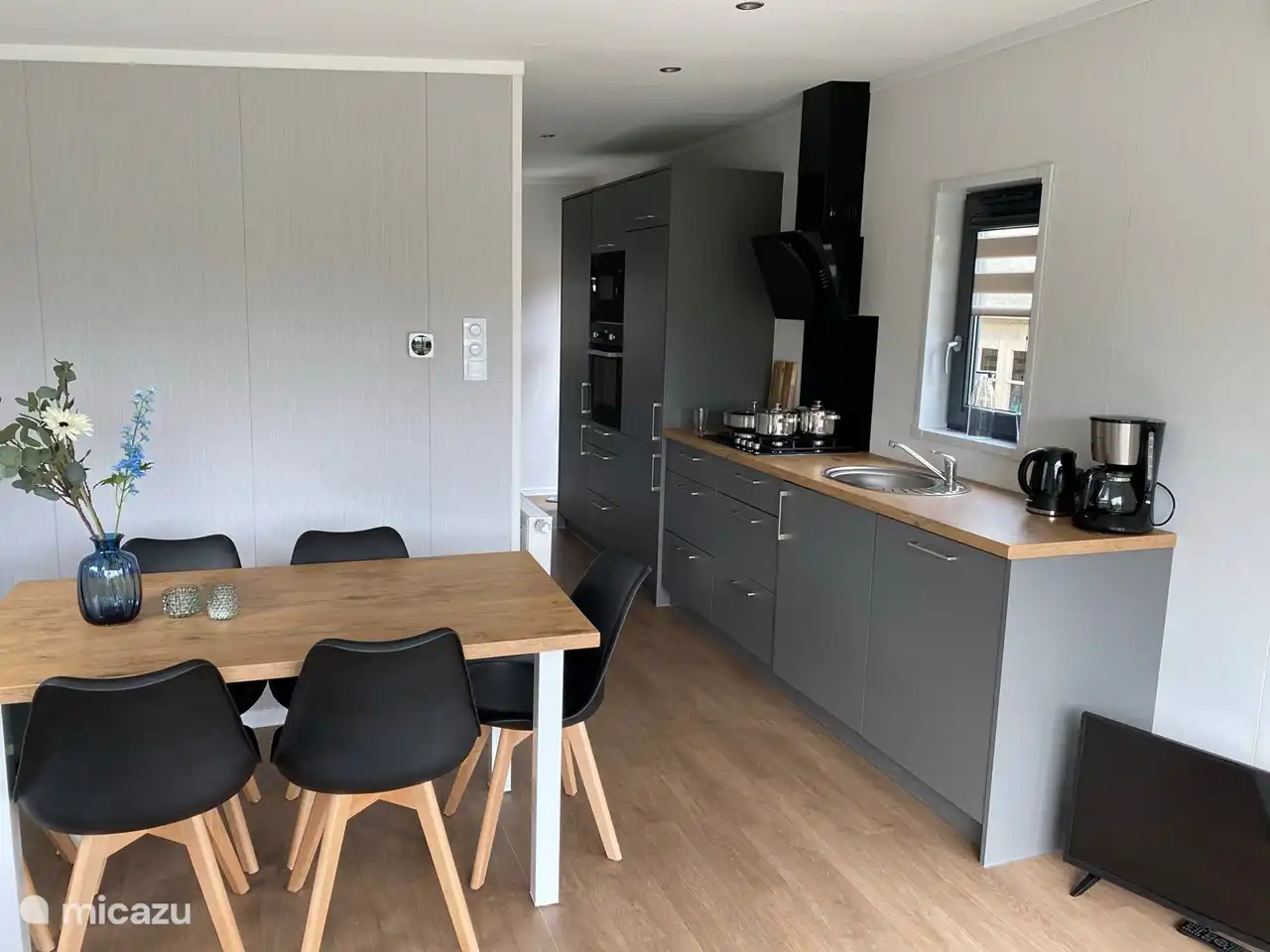 keuken met gasplaat, koelkast, vriezer, oven en magnetron