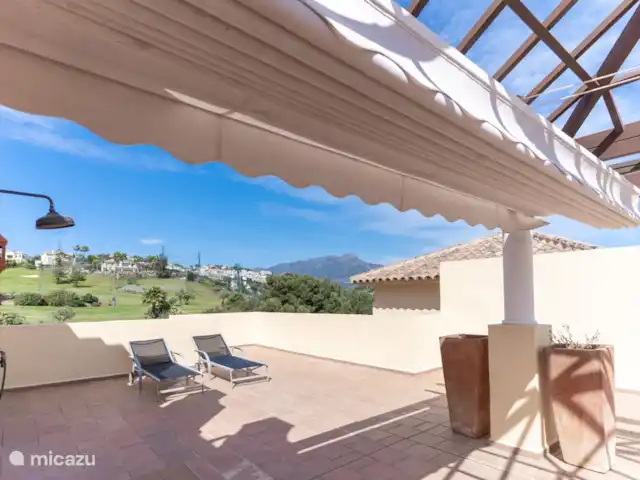 Penthouse Los Arqueros vue mer | Espagne, Costa del Sol, Benahavis - penthouse terrasse sur le toit donnant sur le parcours de golf et le club-house du country club de los arqueros. La terrasse sur le toit a une douche extérieure et un parasol (photo prise lorsque l'ensemble de salle à manger n'était pas encore là)