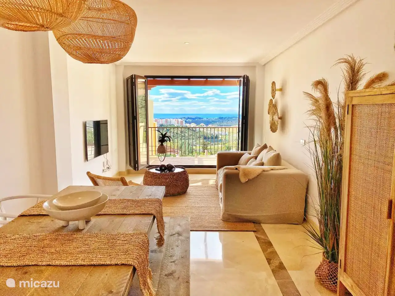 Wohnzimmer mit Esstisch und Sitzecke mit TV. Französische Türen zum Balkon. Sehen Sie auch die fantastische Skyline