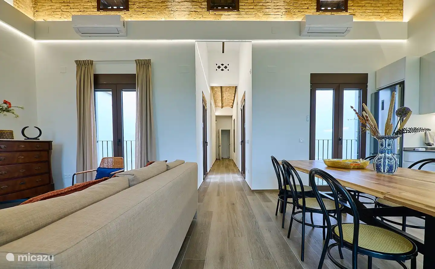 Der lange Flur mit dem Eingang zur Wohnung am Ende und den beiden Schlafzimmern auf beiden Seiten. Die Fenster öffnen sich zur Terrasse.