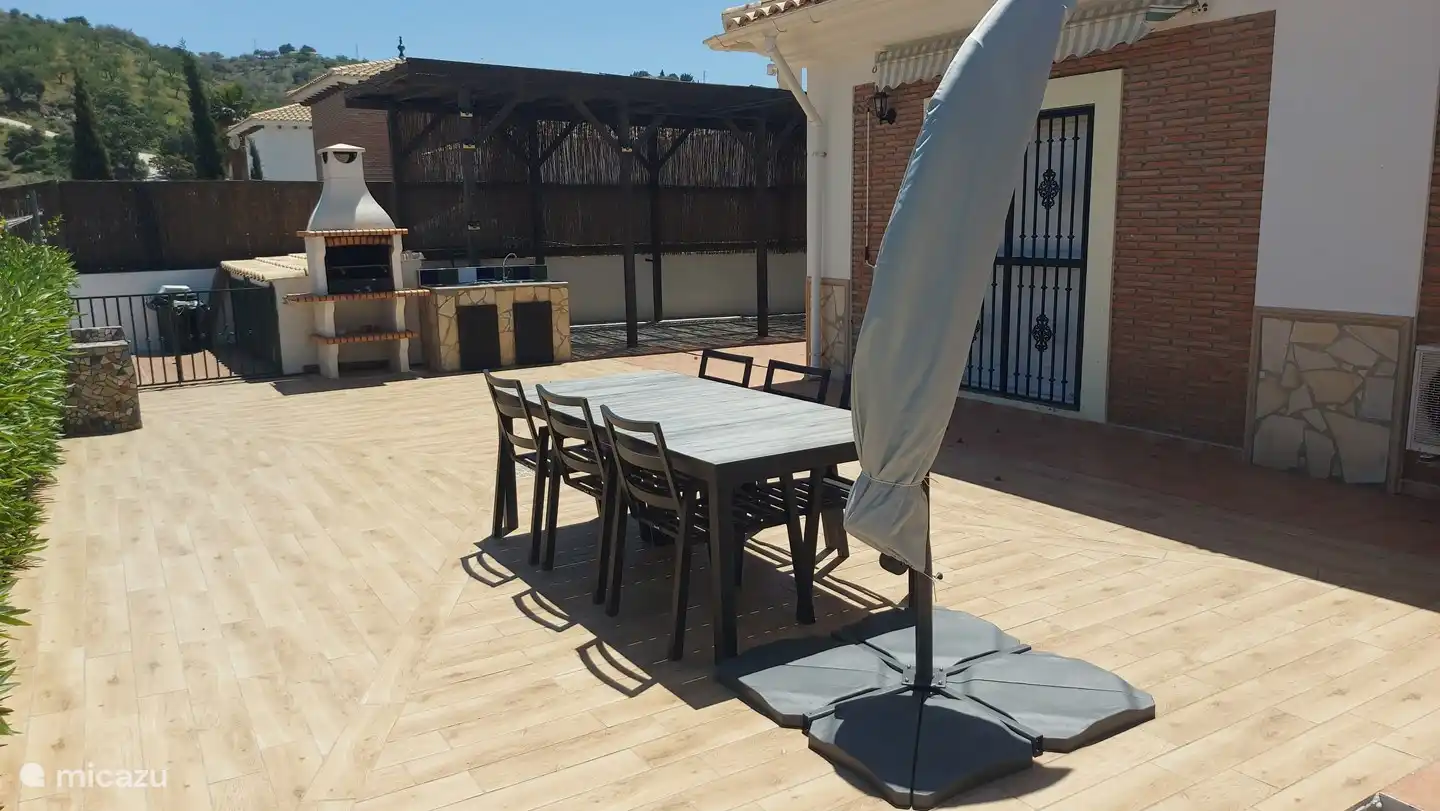 Esstisch auf der großen Terrasse neben dem Grill