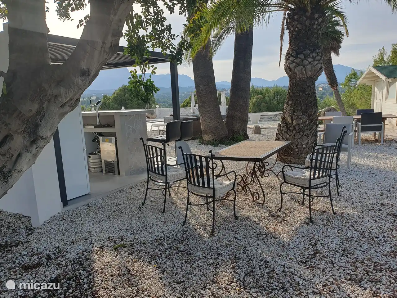 rincón relax con vista a las montañas, piscina y bar