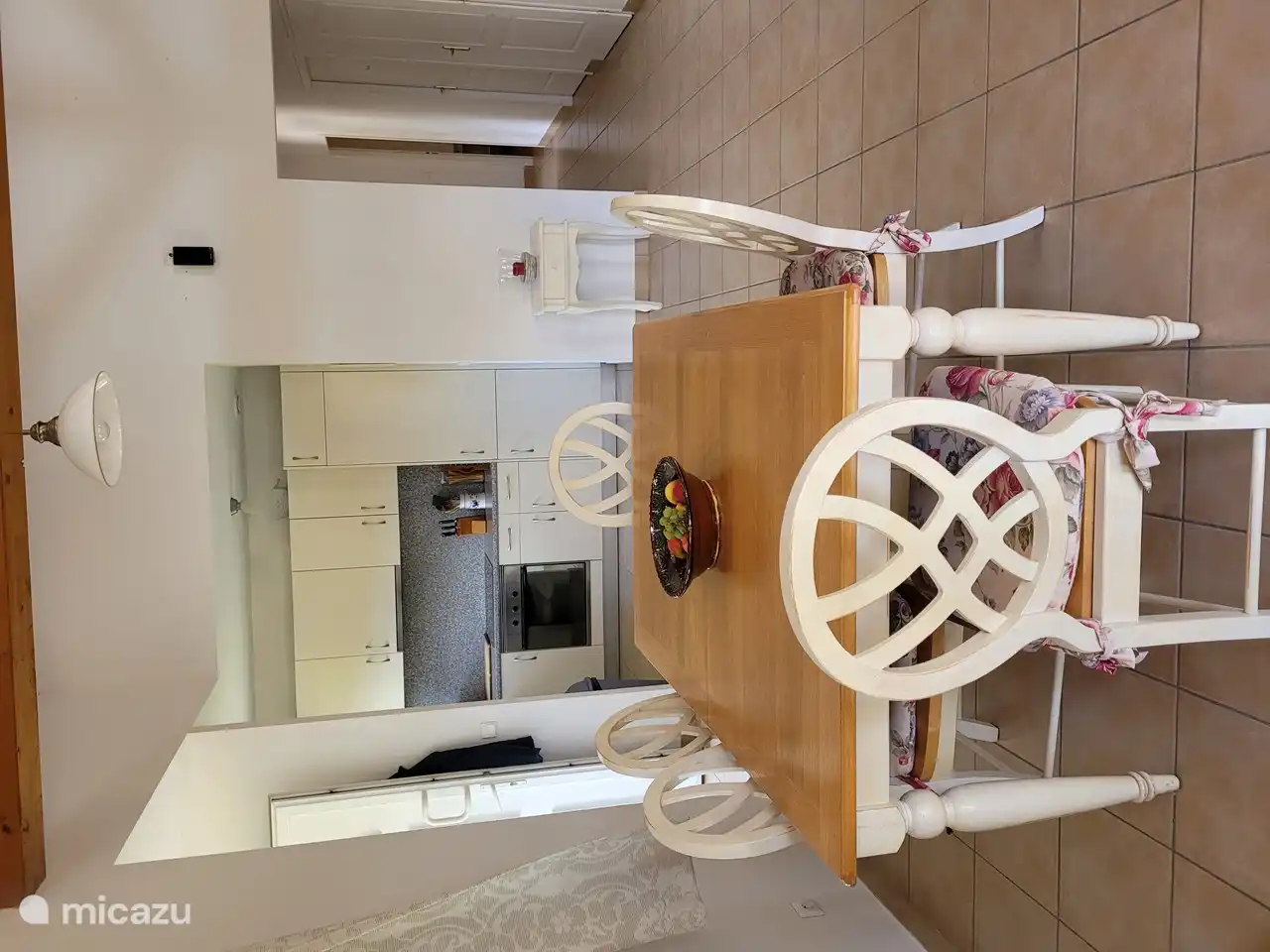 Stabiler Esstisch mit 6 Stühlen. Im Hintergrund die Küche.