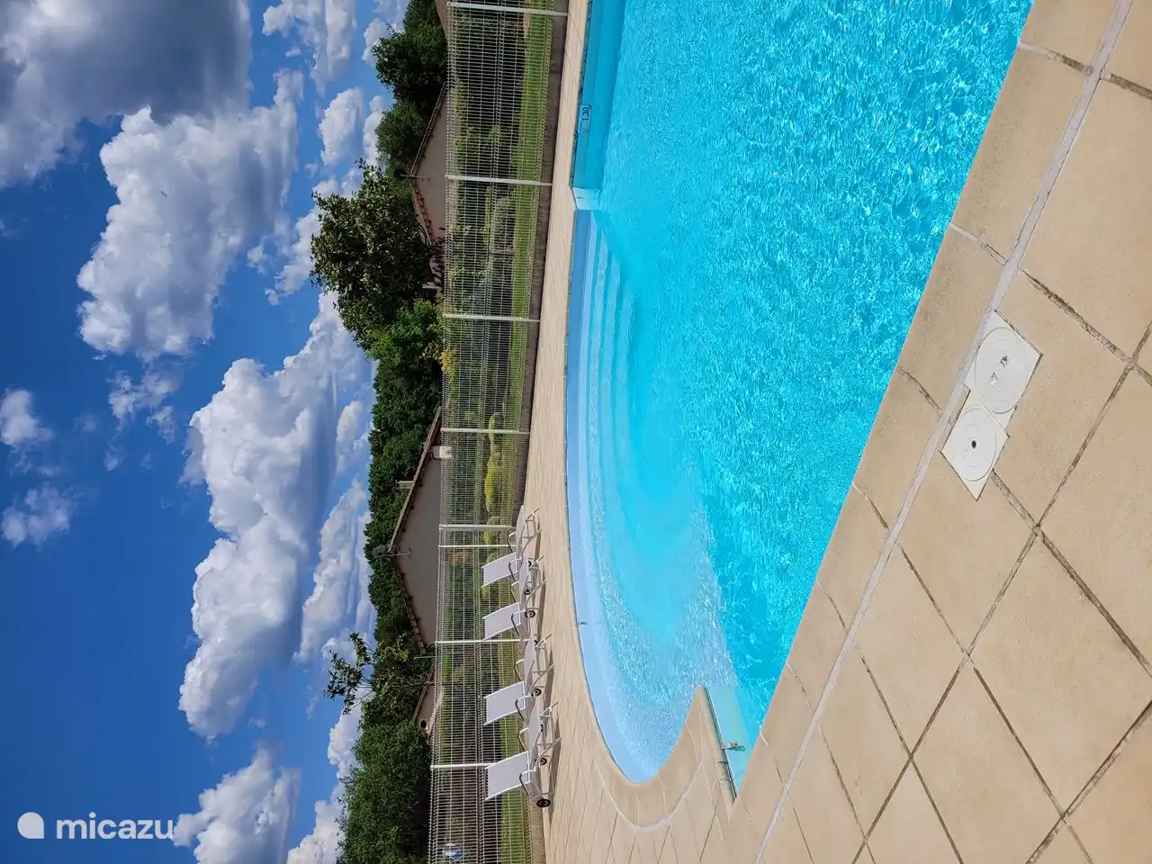 Der schöne Swimmingpool mit Liegestühlen.