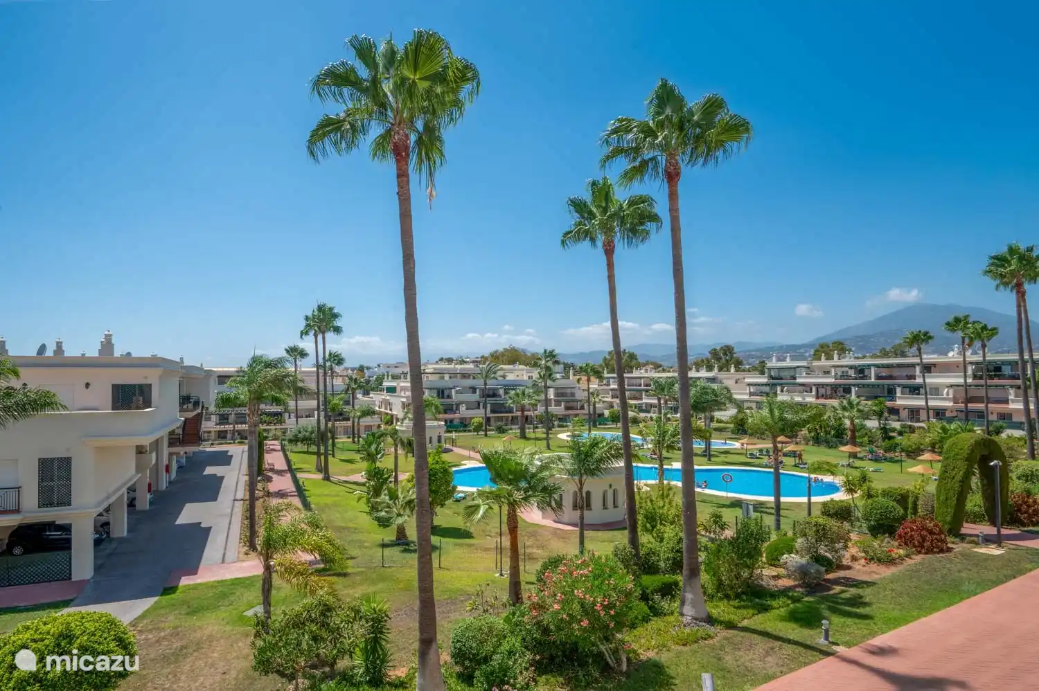 Blick von der Terrasse auf die Gärten mit Swimmingpools: viel Privatsphäre!