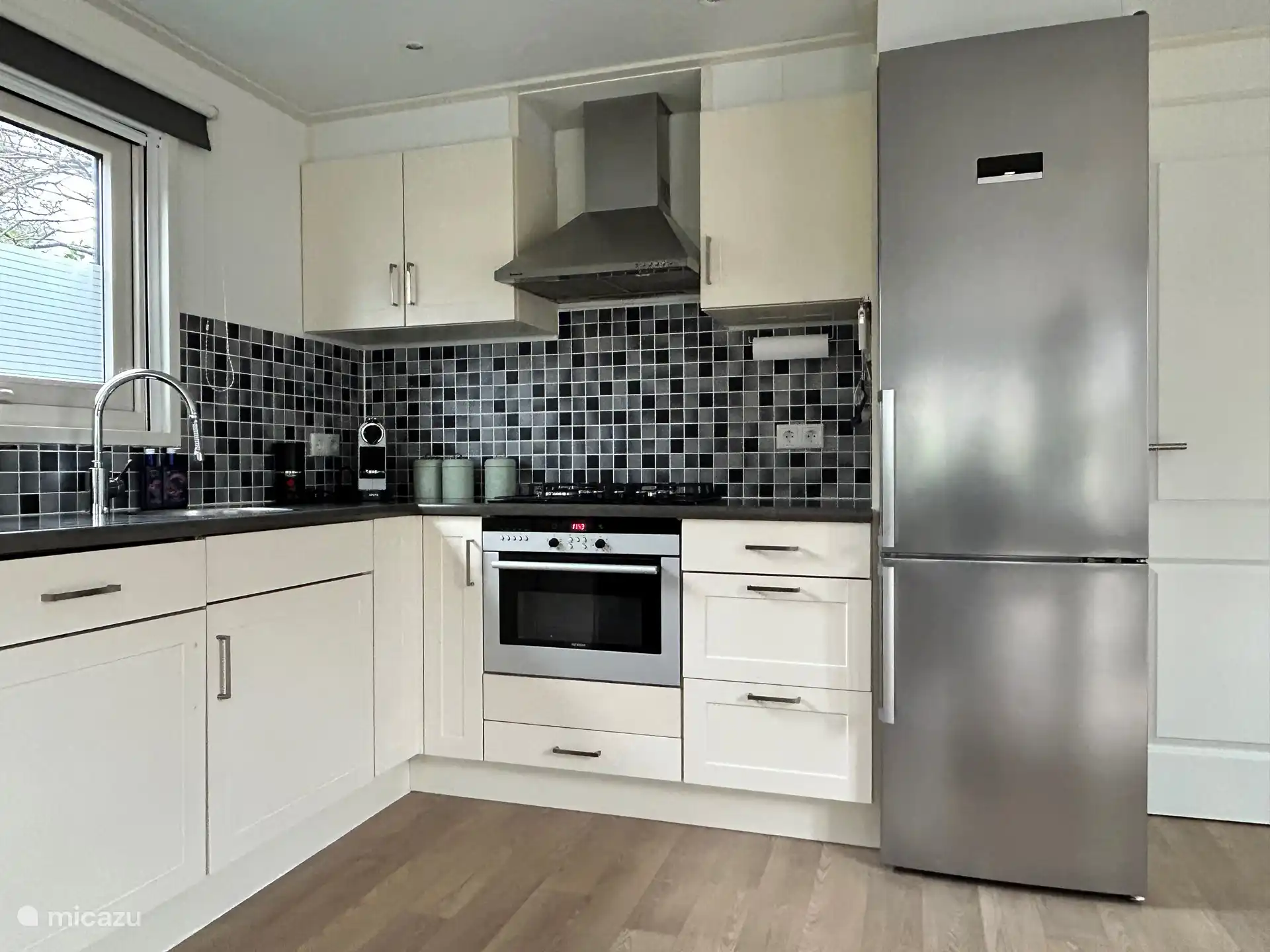 Moderne Luxusküche mit Geschirrspüler, Backofen/Mikrowelle, großer Kühl-/Gefrierkombination sowie Nespresso-Maschine und Milchaufschäumer