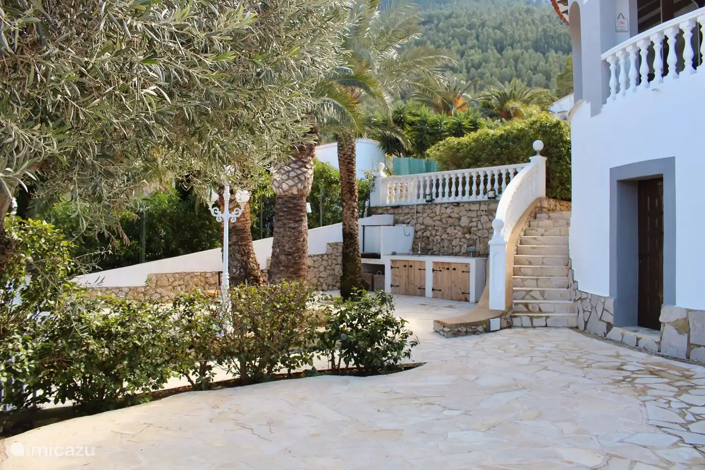 The garden to the left of the house with lounge set and outdoor kitchen