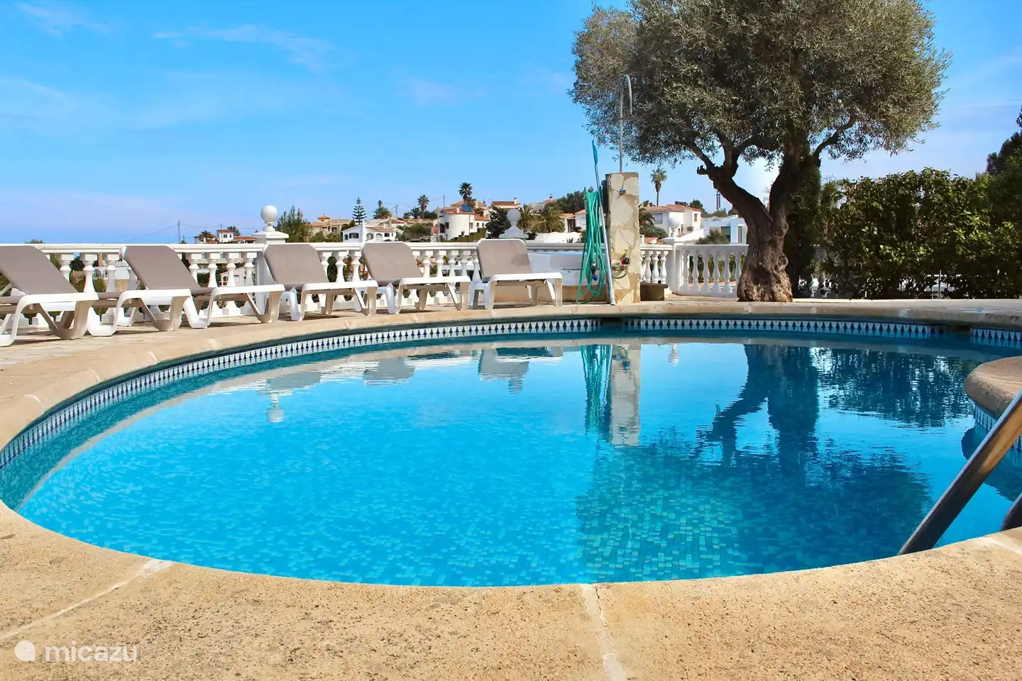 An overview of the 8x4 kidney shaped swimming pool with lighting in the evening.
