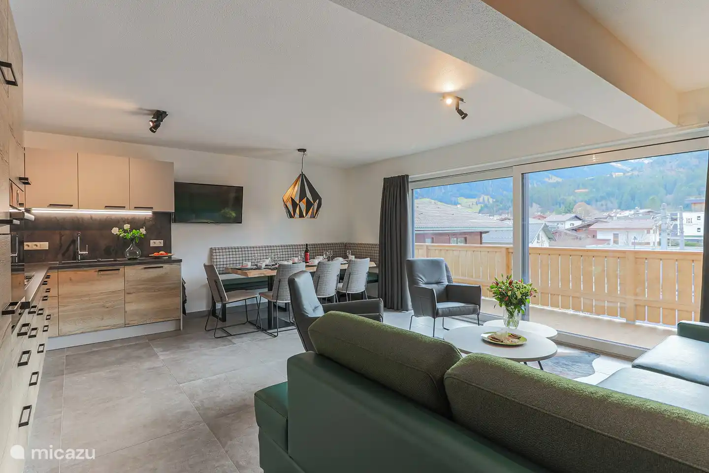 Kamer met hoekbank (tevens slaapbank) eethoek en volledig ingerichte keuken met afwasmachine en het luchtoven.