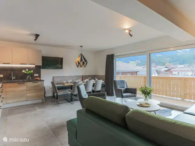 Residencia Brixental Top 7 en Austria, Tirol, Brixen im Thale - apartamento Habitación con sofá esquinero (también sofá cama), comedor y cocina totalmente equipada con lavavajillas y horno de aire.