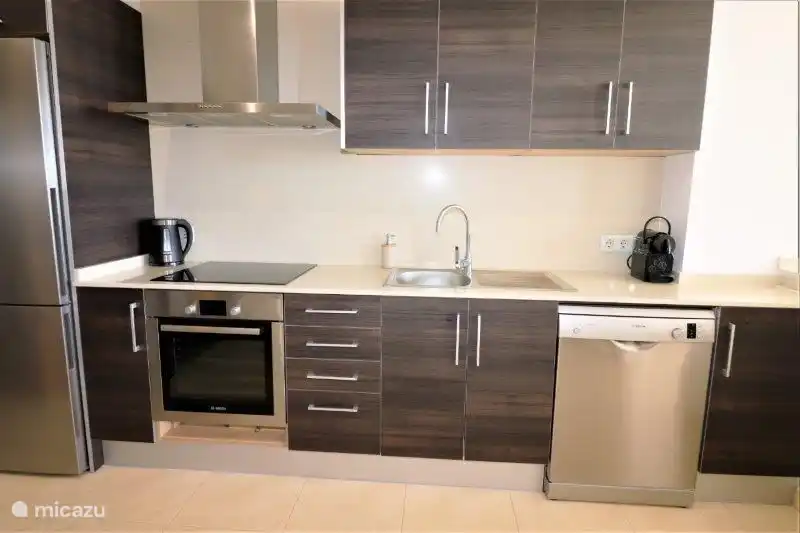 Voll ausgestattete halboffene Küche.