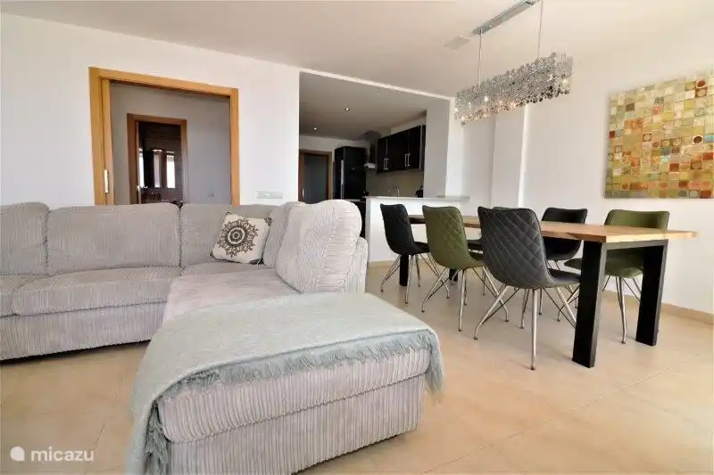 Gemütliches Wohnzimmer mit Schiebetüren zur Terrasse. Eine Treppe führt Sie hinunter zum Gemeinschaftspool.