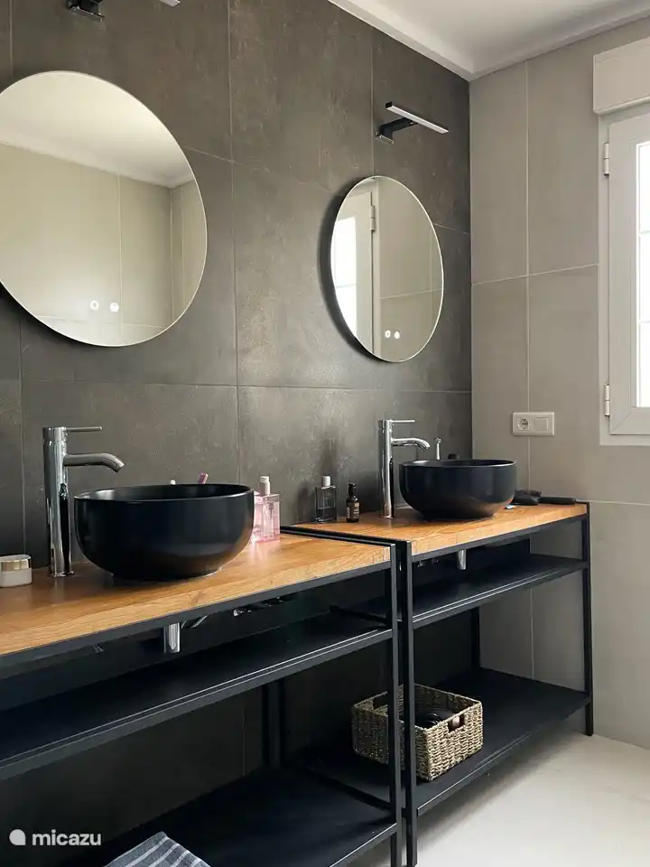 baño adyacente al dormitorio principal; dos lavabos, ducha y WC