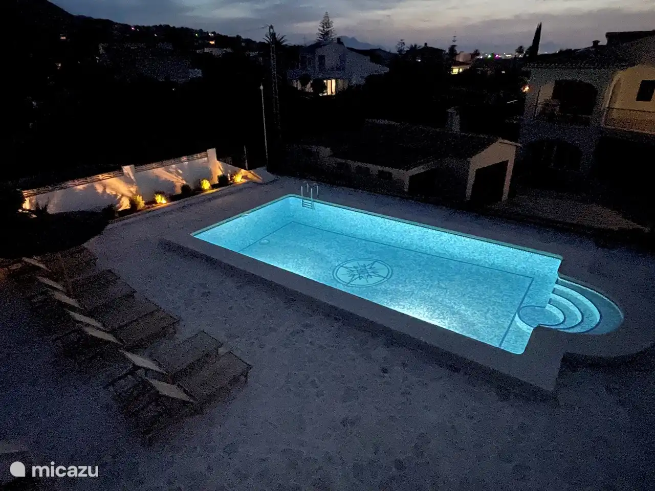 la piscina está iluminada por la noche