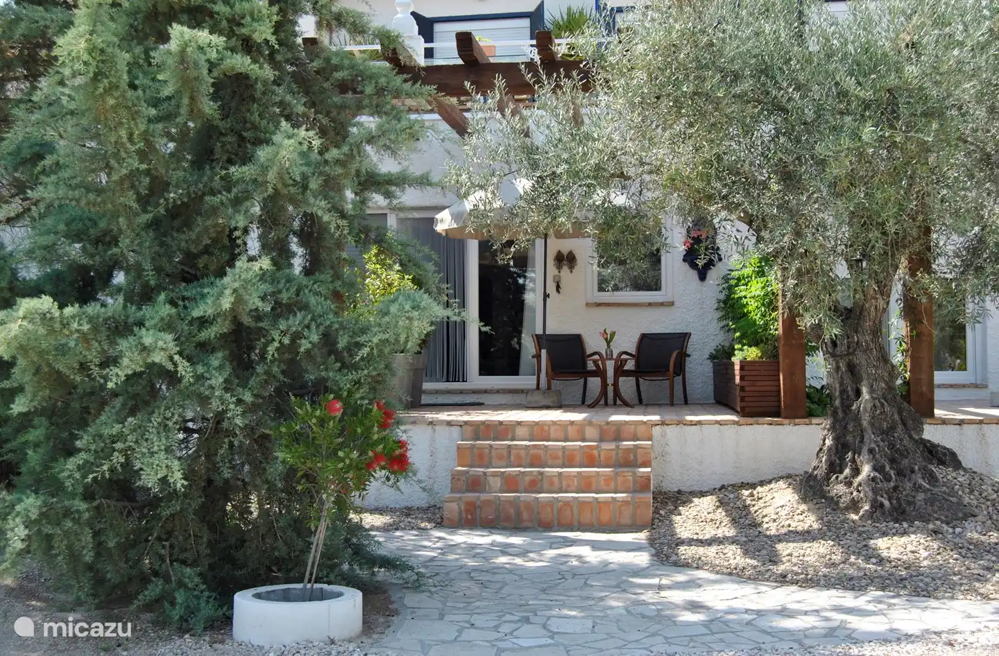 Eigene private Terrasse mit Sitzgelegenheit und Sonnenschirm.