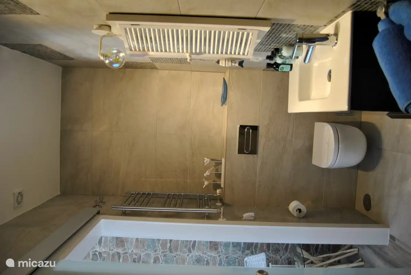 Luxuriöses Badezimmer mit ebenerdiger Regendusche, Waschbecken mit Spiegel.