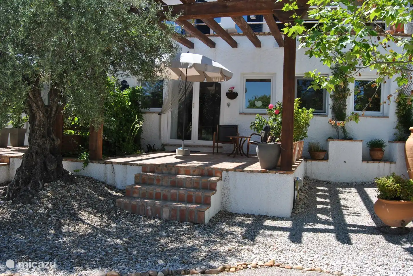 Eigene private Terrasse mit Sitzgelegenheit und Sonnenschirm.