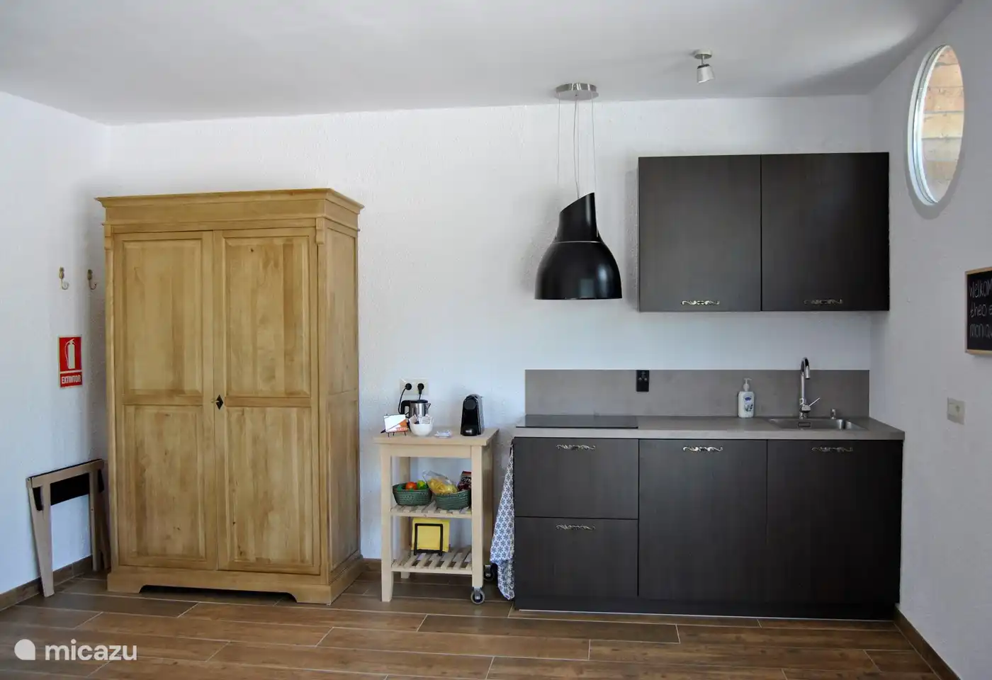 Hochwertige Küche mit Kühlschrank, Mikrowelle, Induktionskochfeld und Dunstabzug. Kaffee-/Teekocher mit Nespresso-Maschine und Wasserkocher.