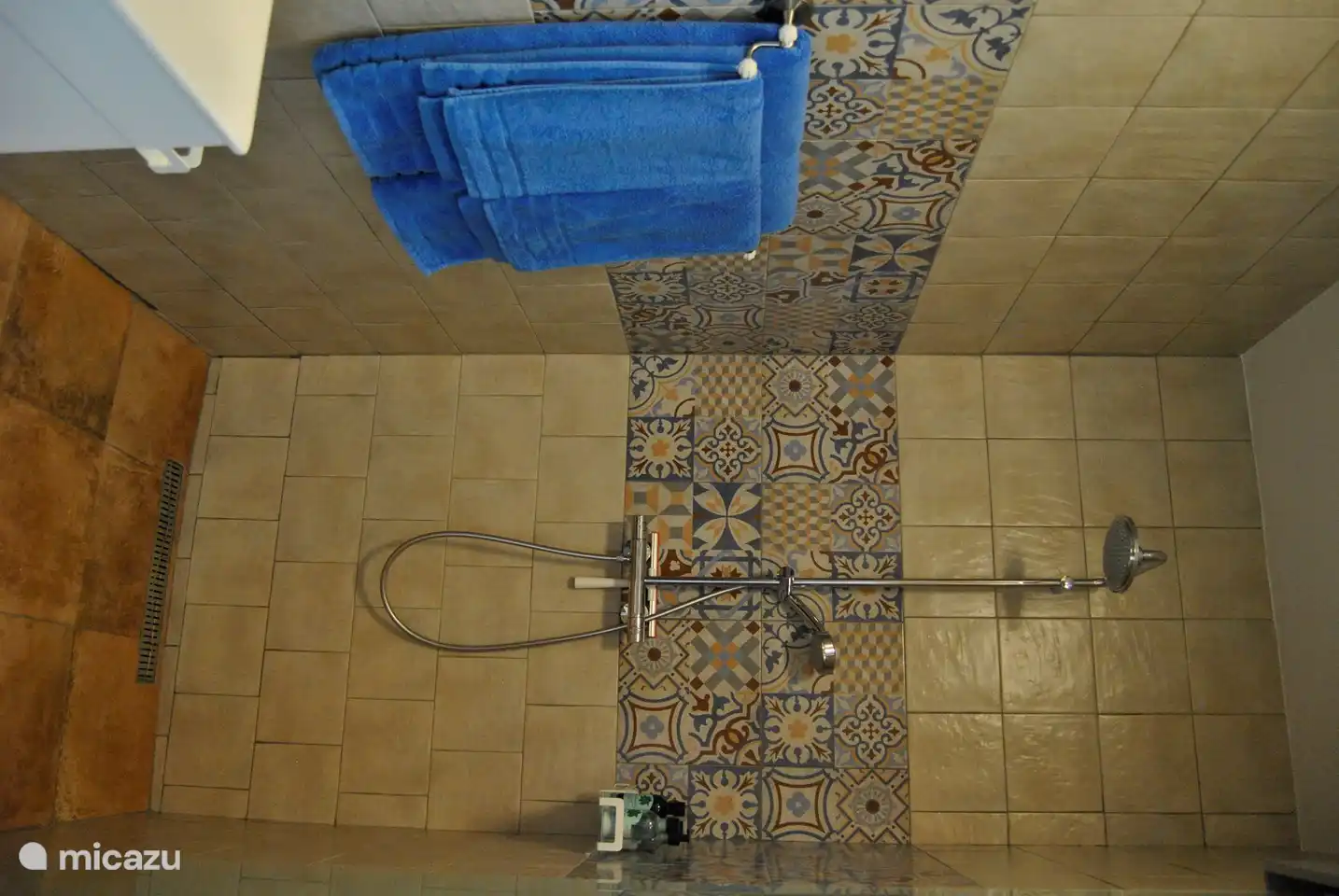 Luxuriöses Badezimmer mit ebenerdiger Regendusche, Waschbecken mit Spiegel.