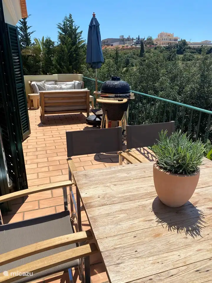 BAlkon con varias zonas de estar y mesa de comedor