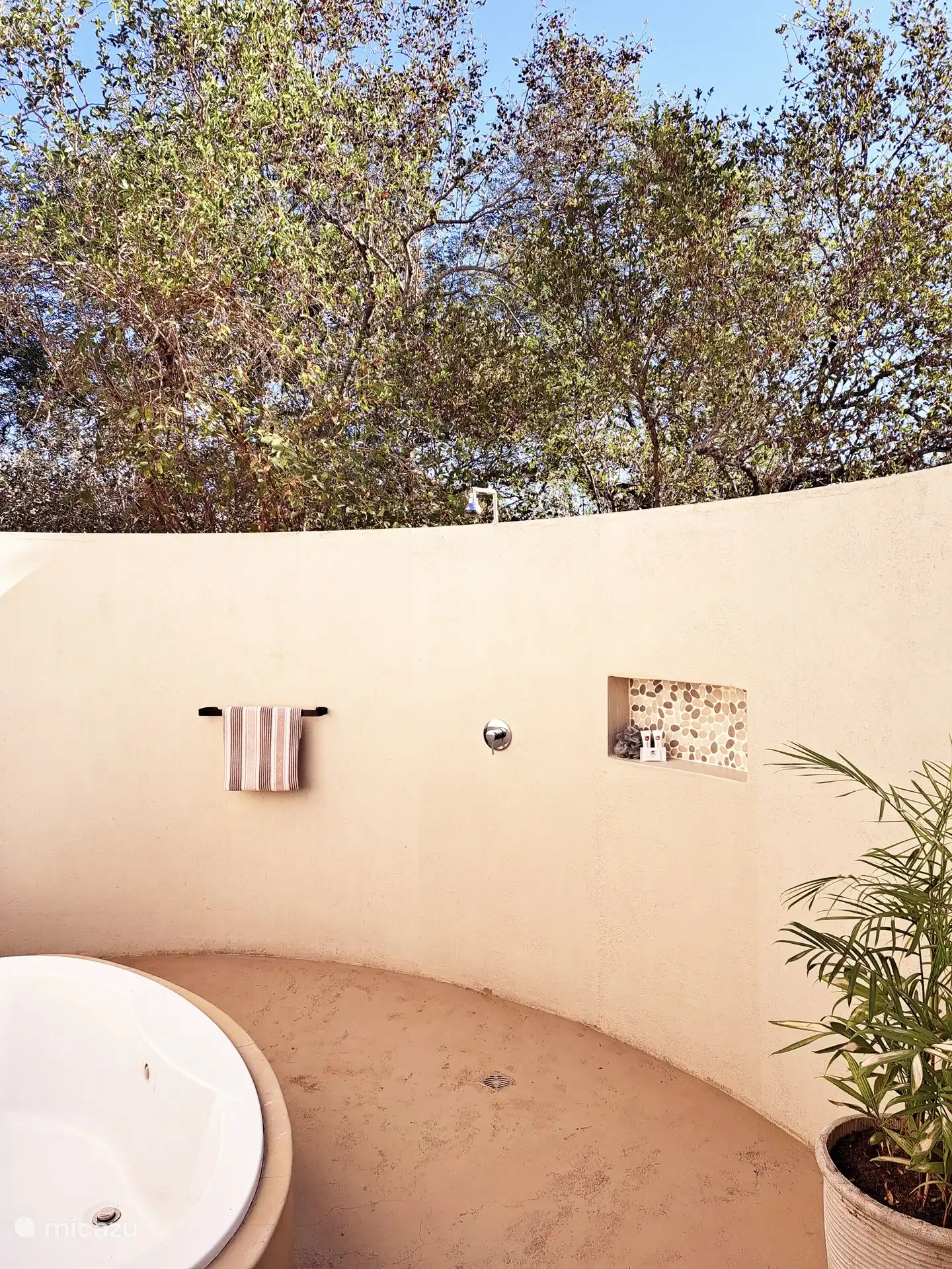 La salle de bain extérieure confortable avec baignoire et douche.