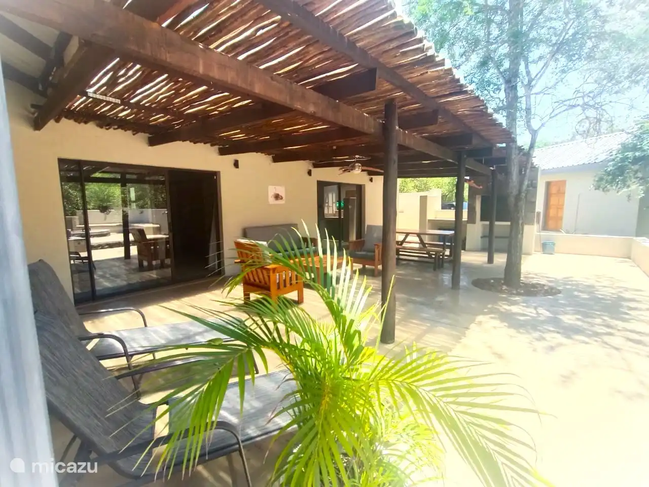 Patio avec salon de salon, chaises longues, table à manger et braai