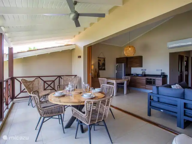 Quartier Jan Thiel | appartement B7 | Curaçao, Banda Ariba (est), Spaanse Water - appartement Balcon ombragé avec table à manger et portes ouvertes sur la zone intérieure.