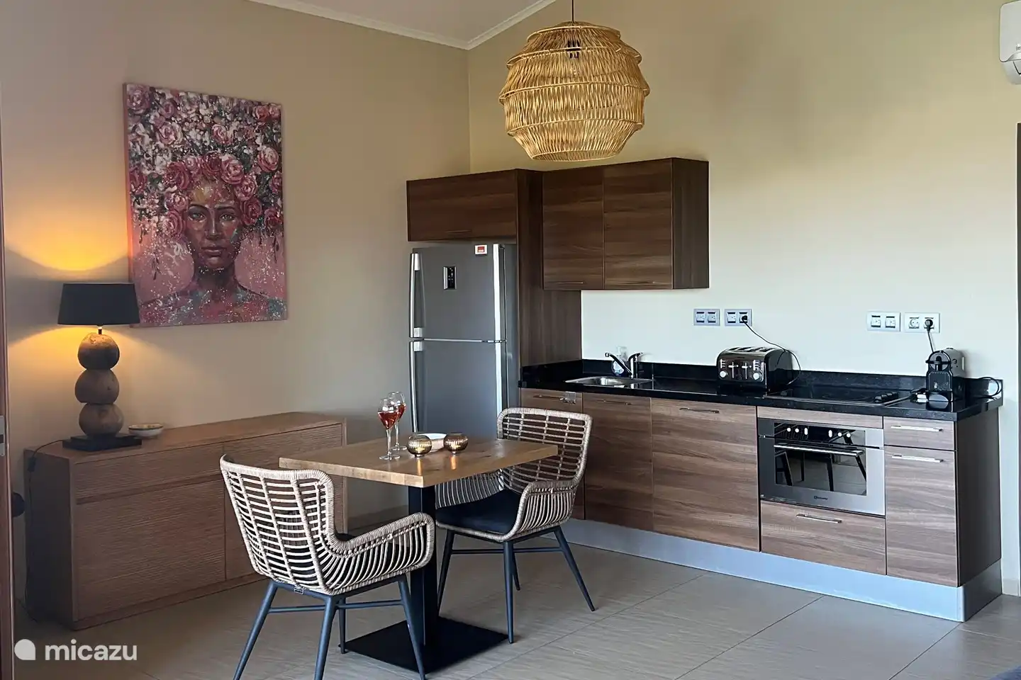 Cocina abierta con vitrocerámica y cafetera Nespresso.