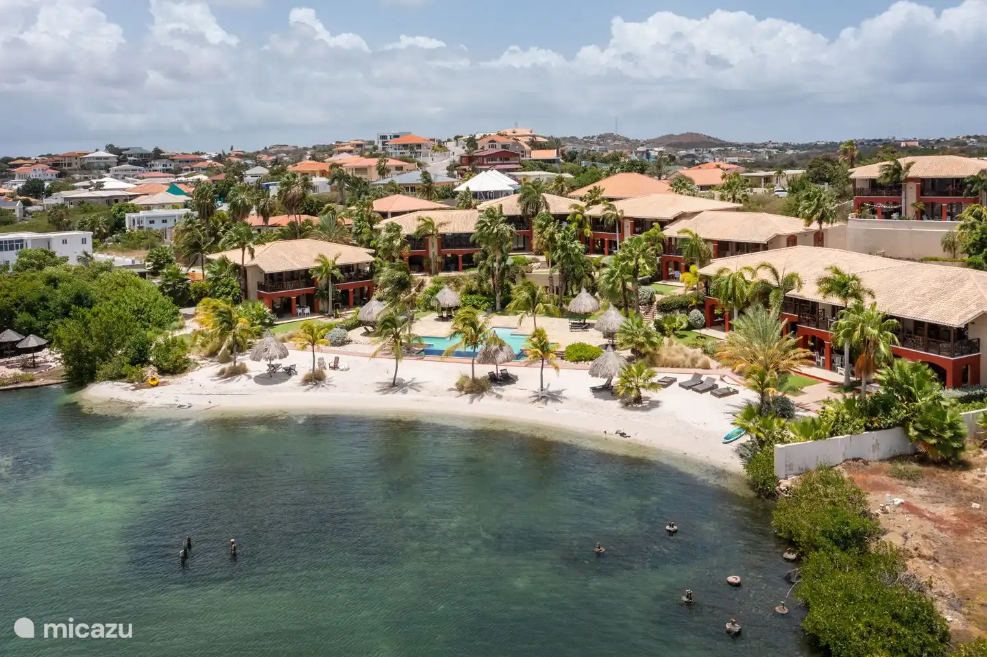 Vista de pájaro sobre el complejo con piscina y playa.