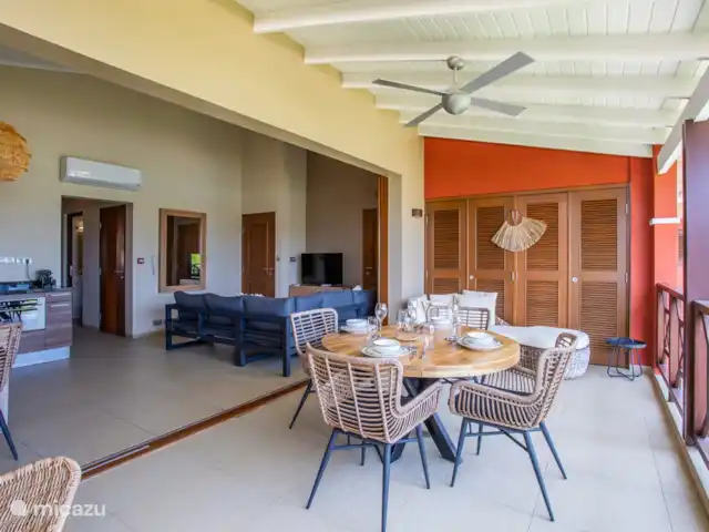 Quartier Jan Thiel | appartement B7 | Curaçao, Banda Ariba (est), Spaanse Water - appartement Balcon ombragé avec table à manger et portes ouvertes sur la zone intérieure.