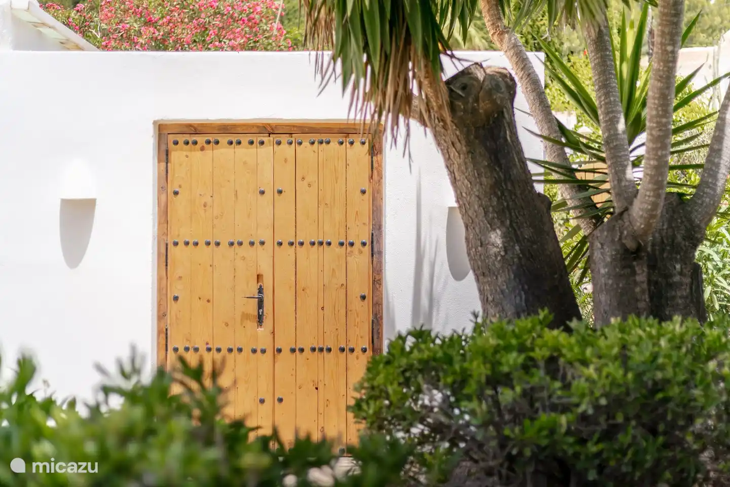 Vous entrez dans le jardin méditerranéen par les portes en bois faites à la main