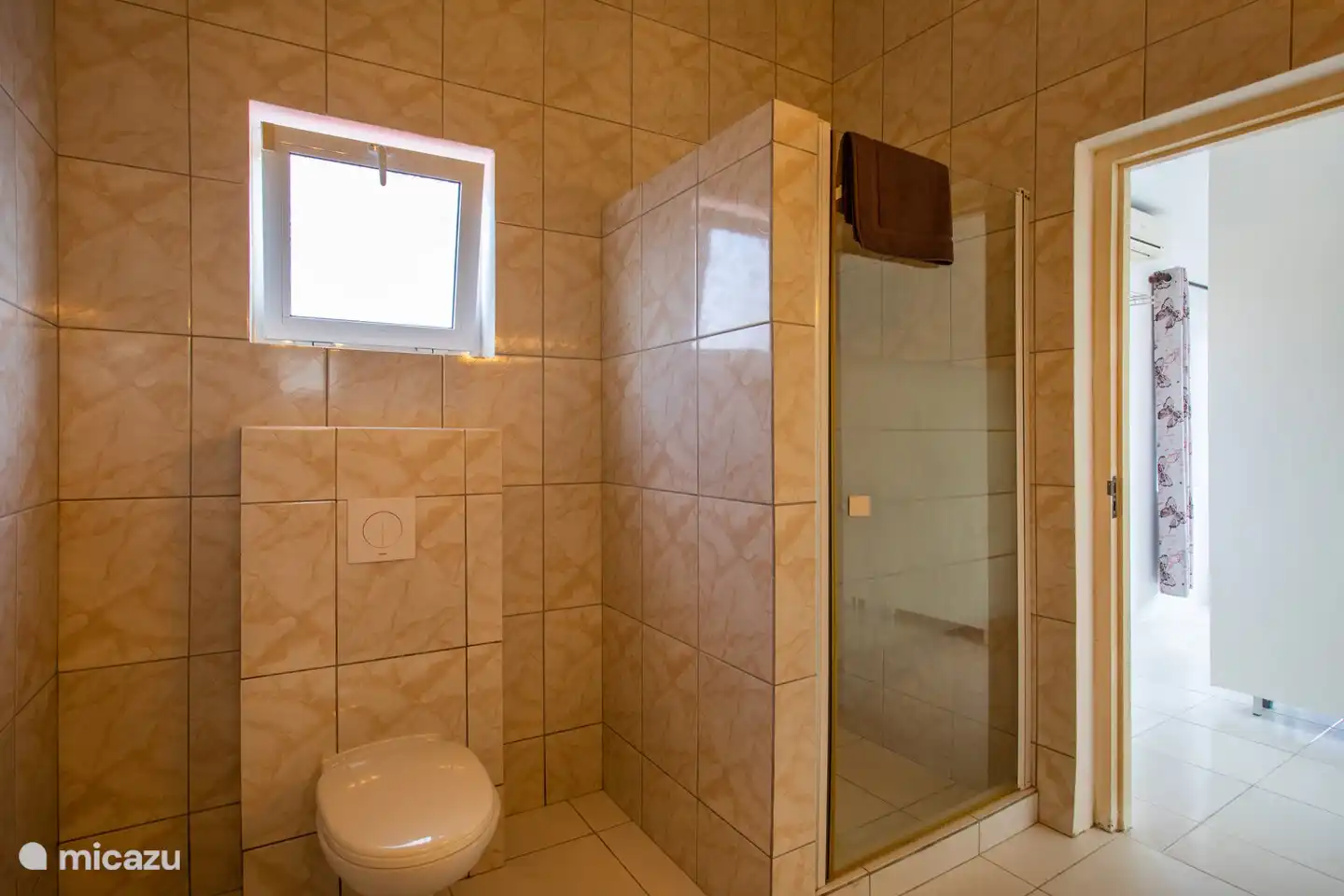 Geräumiges Badezimmer mit Dusche, Waschbecken und Toilette