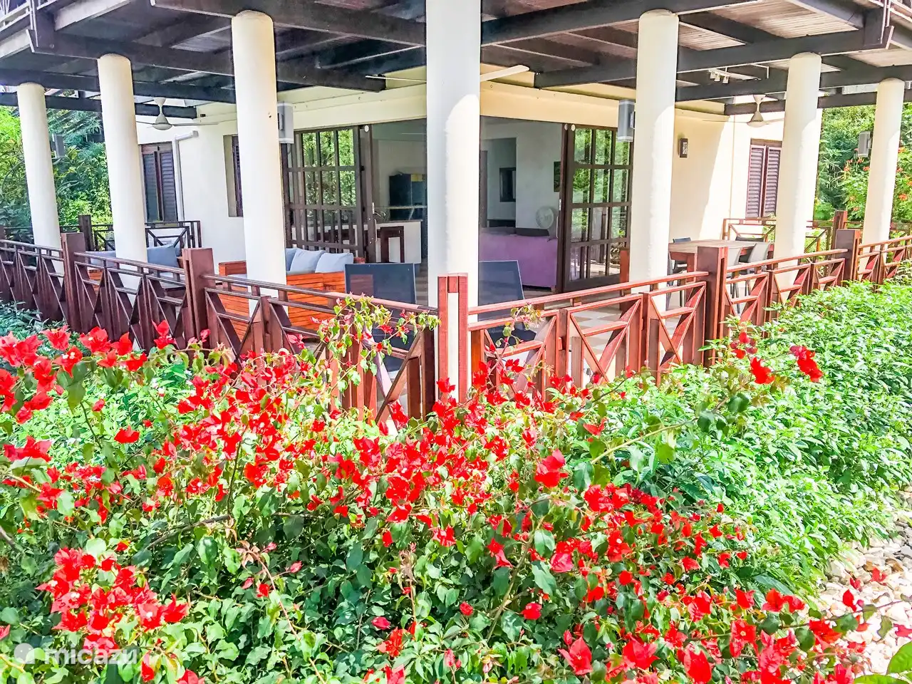 Preciosa y espaciosa terraza cubierta con ventiladores, juego de salón, tumbonas y mesa de comedor.