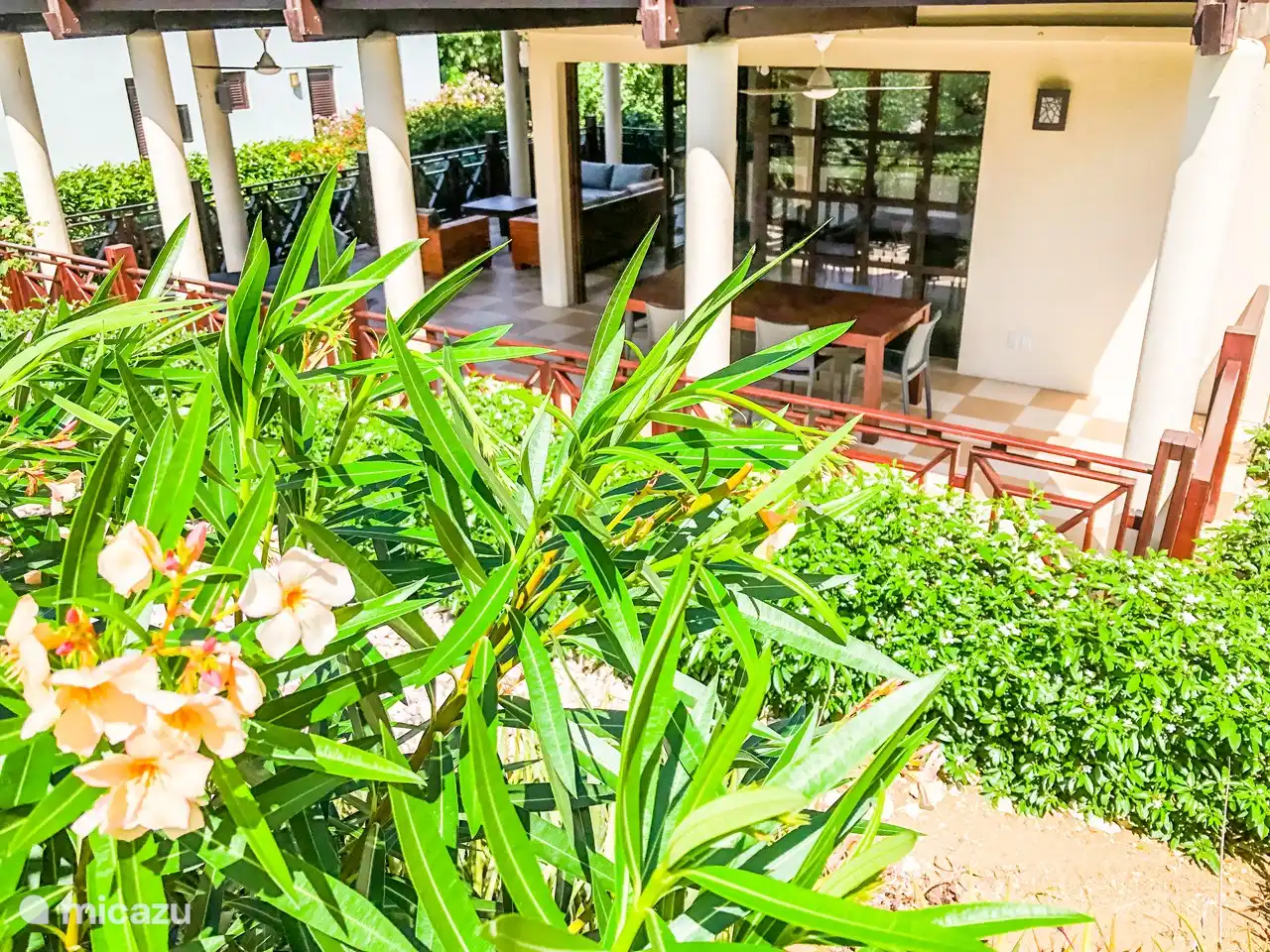 Preciosa y espaciosa terraza cubierta con ventiladores, juego de salón, tumbonas y mesa de comedor.