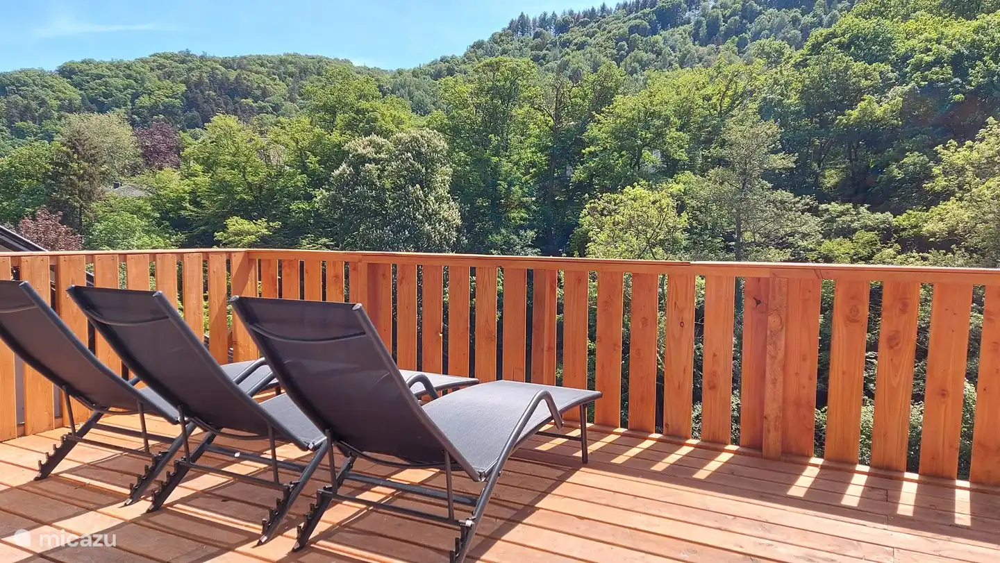 Acogedor jardín con barbacoa y solarium con tumbonas. En el borde del bosque y las rocas.