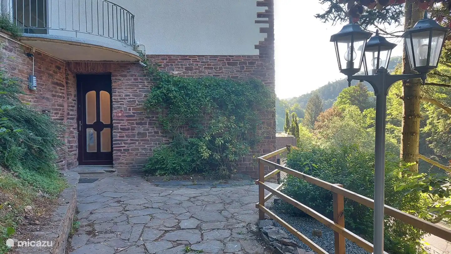 Entrada de la casa, se llega aquí tomando una pasarela de 30 metros con 10 escalones. También hay un balcón en este lado.