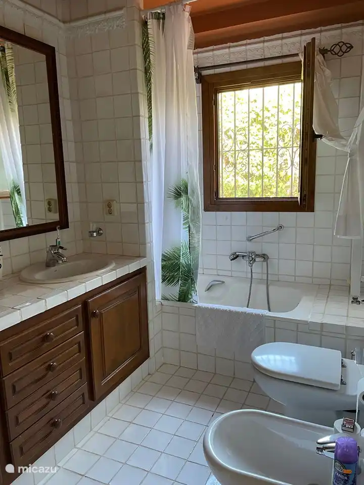 Salle de bain avec double vasque, baignoire avec douche, bidet et WC
