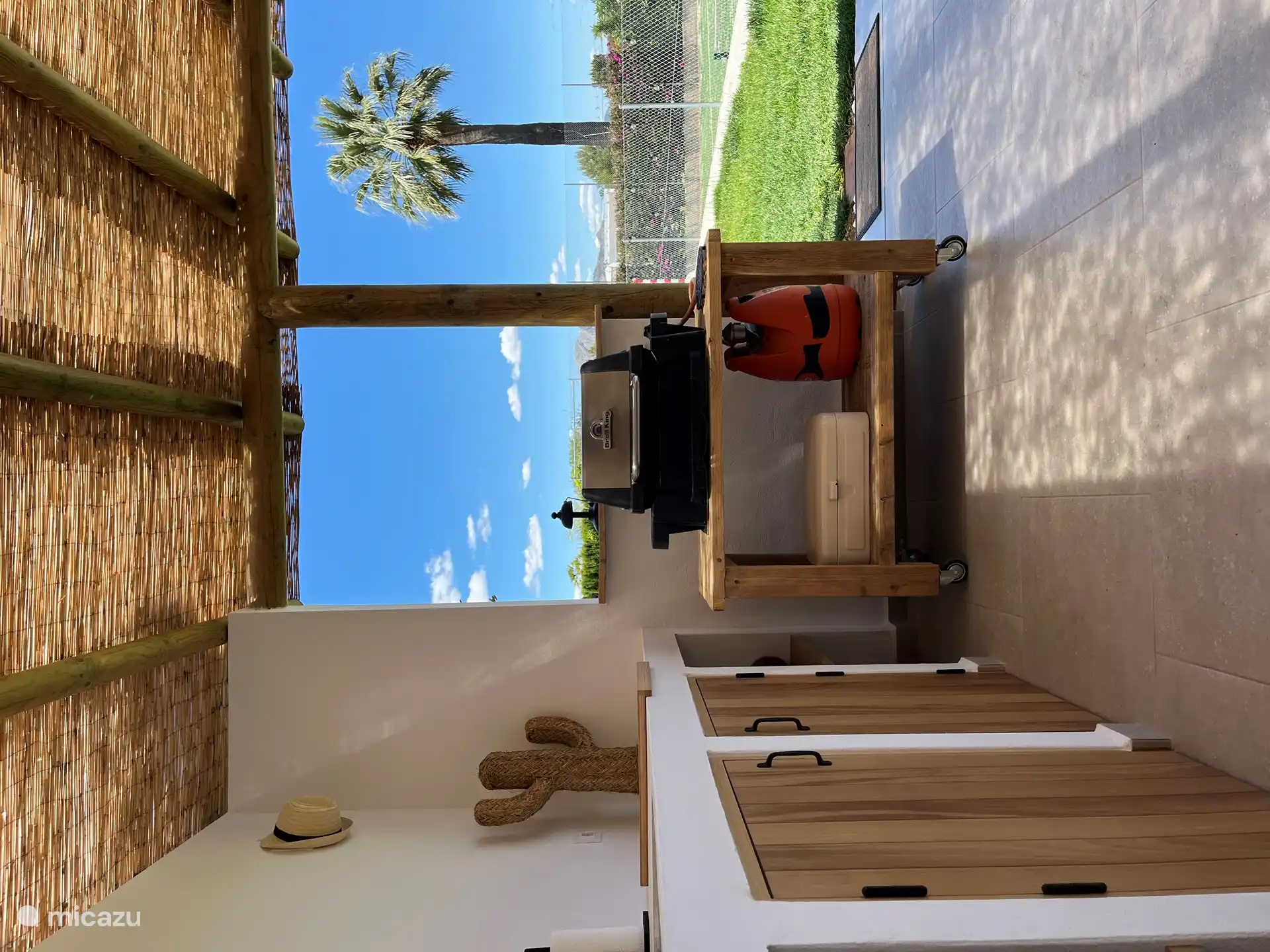 La cocina exterior está equipada con barbacoa, nevera pequeña, agua fría y caliente y varios utensilios de cocina.