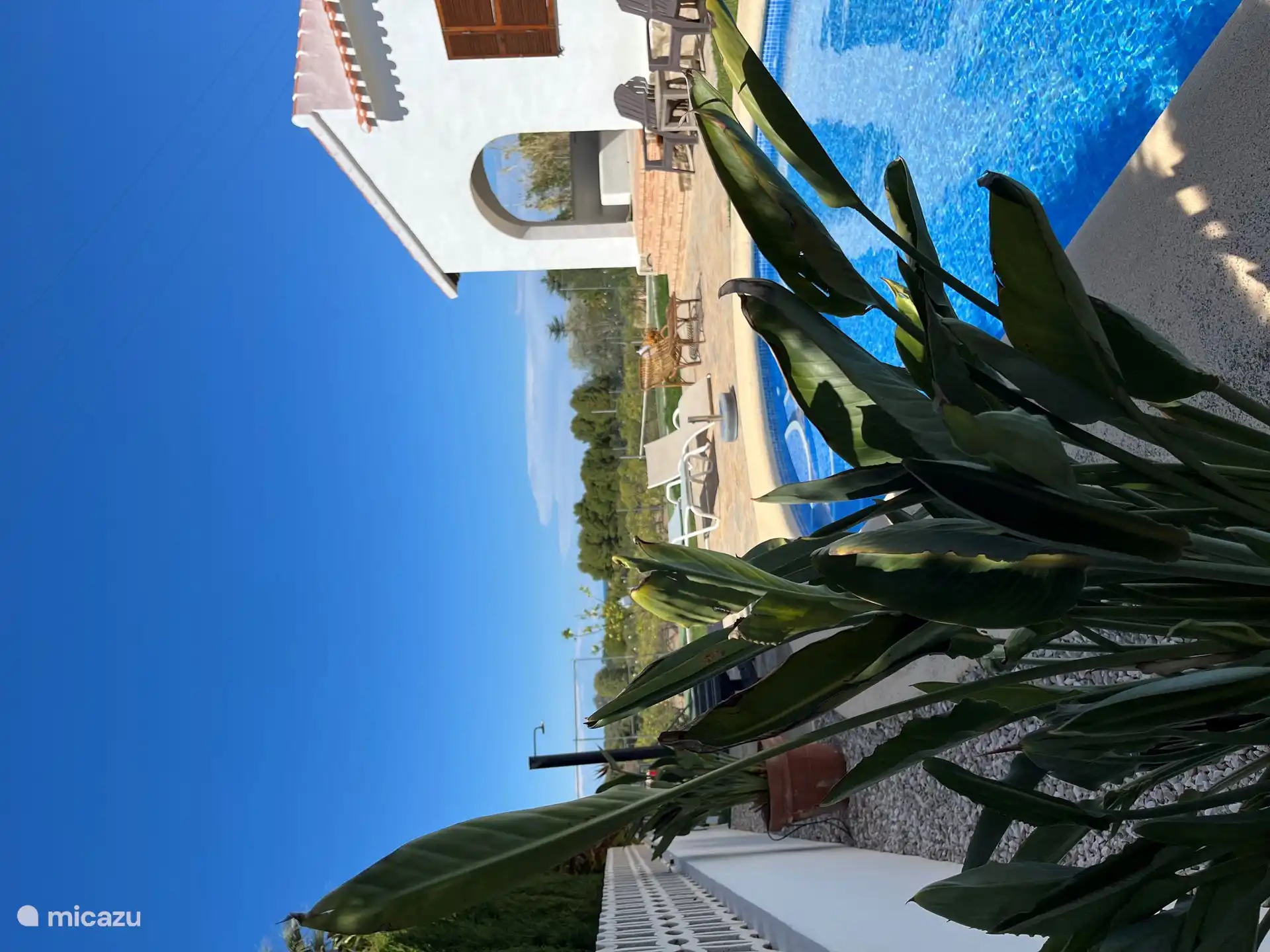 Piscina desde un ángulo diferente, con la ducha exterior a la izquierda.