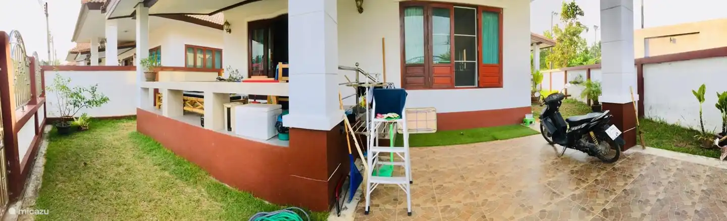 Este es el frente de la casa con espacio suficiente para un auto y scooters (cubiertos).