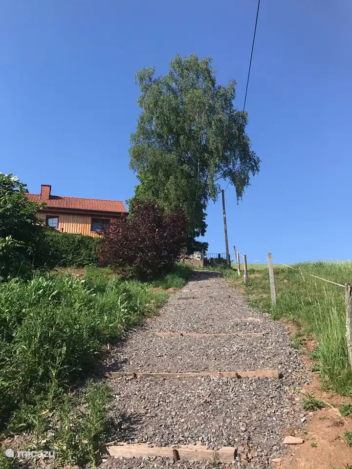 Eingang auf der rechten Hausseite direkt zur Rasenfläche unter der Terrasse.