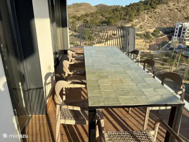 appartement huren in Spanje, Costa Blanca, Villajoyosa – Penthouse Atico Bay grote eettafel bij de keuken en woonkamer op een overdekt terras