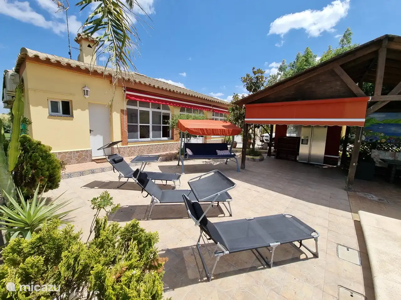 Neben dem Haus können Sie einen ruhigen Moment auf einer der Sonnenliegen oder der Hollywoodschaukel genießen.