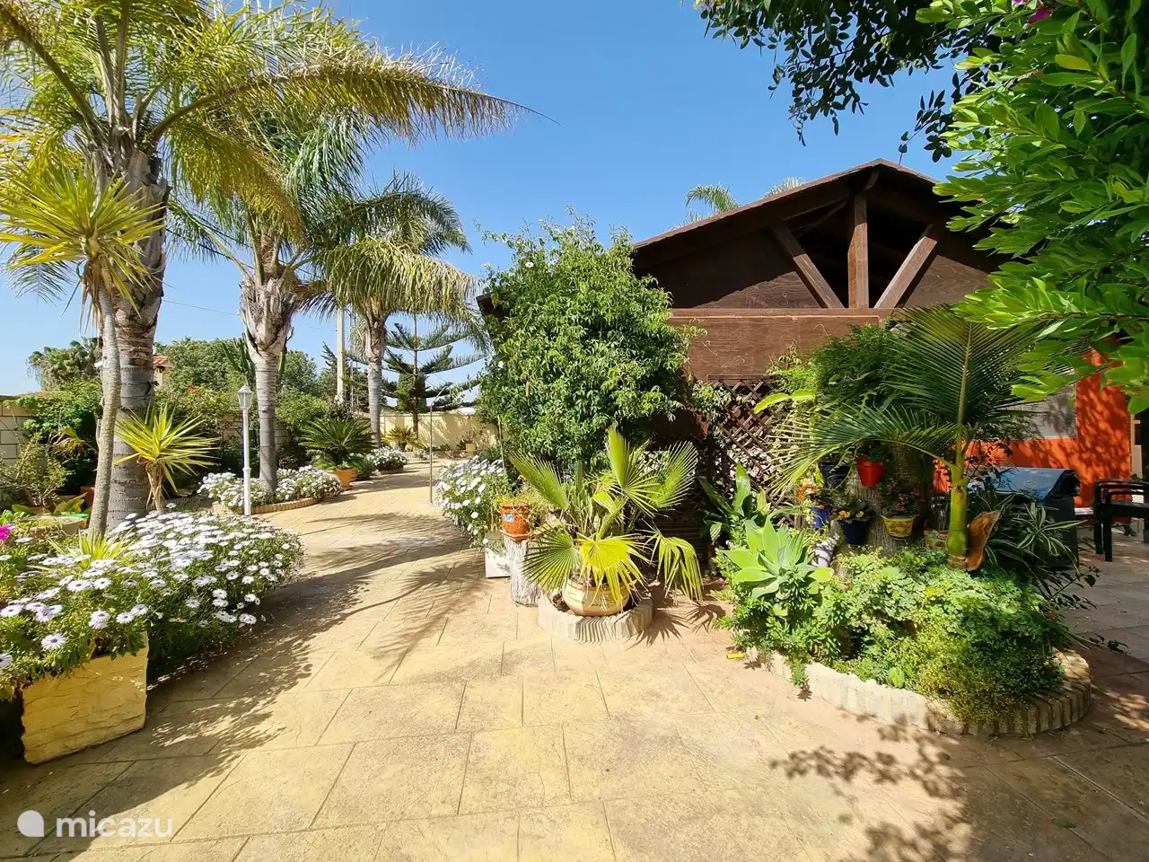 Holzveranda neben dem Pool, mitten im Garten.