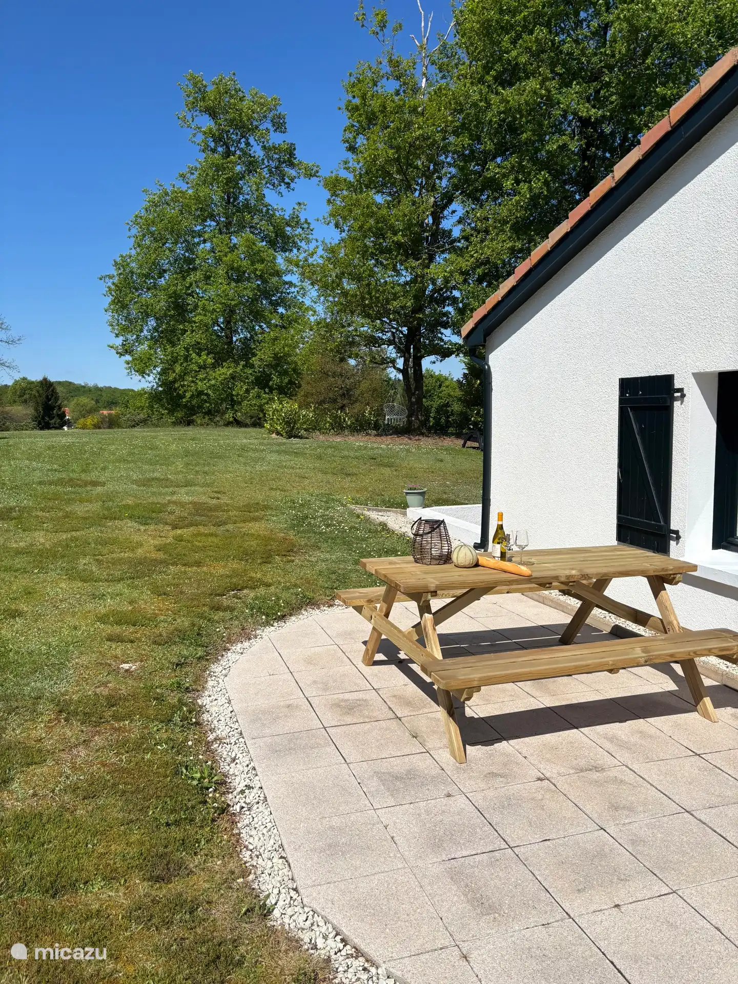 Side terrace with beautiful large new picnic table (2025). Enjoy a beautiful view with a cup of coffee or croissant