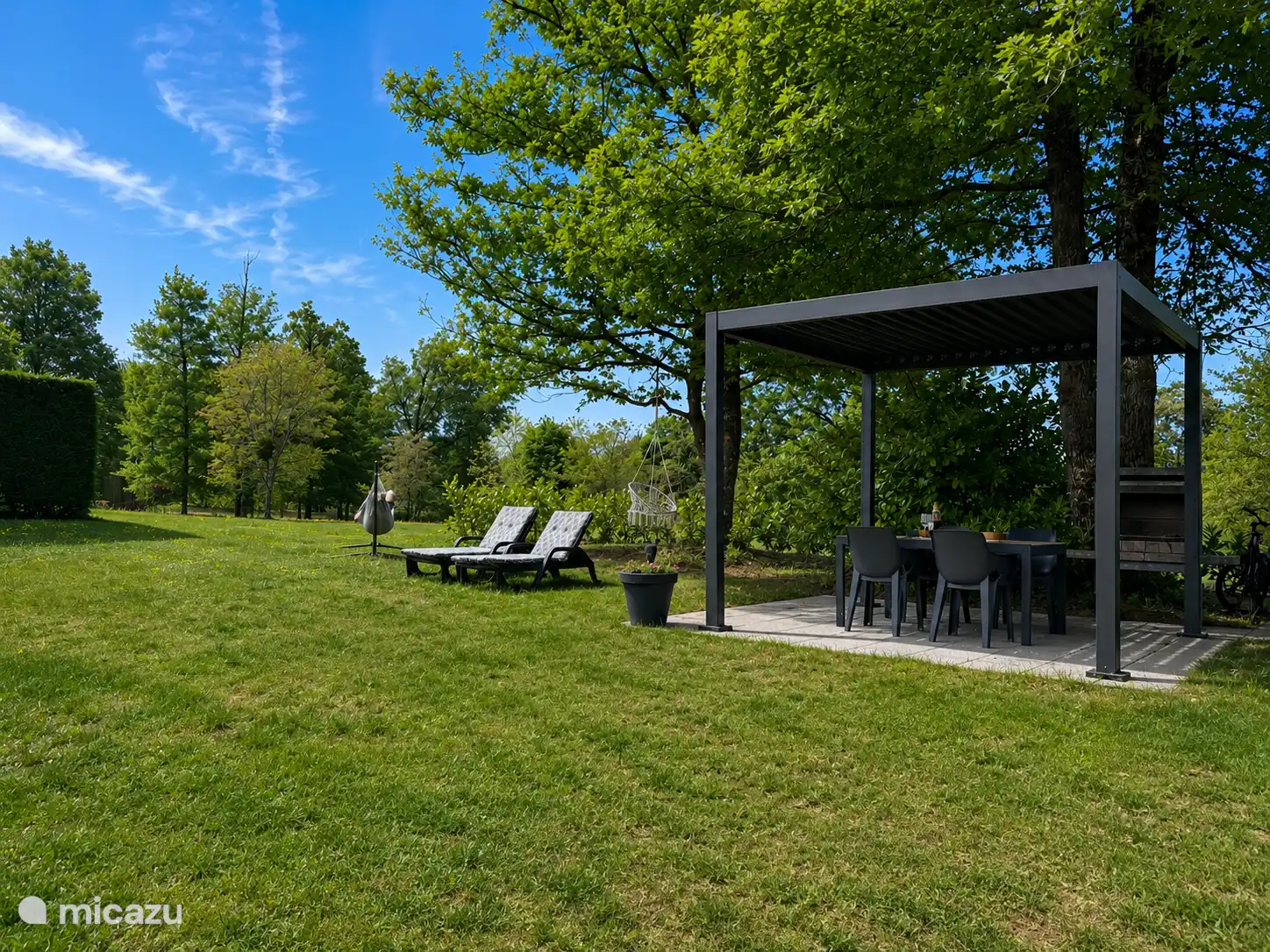 Nieuw (3e) terras met pergola in achtertuin. Gezellig onder de grote boom, volop schaduw voor de warme dagen. Hier staat ook de (vaste) bbq en de zonnebedden.