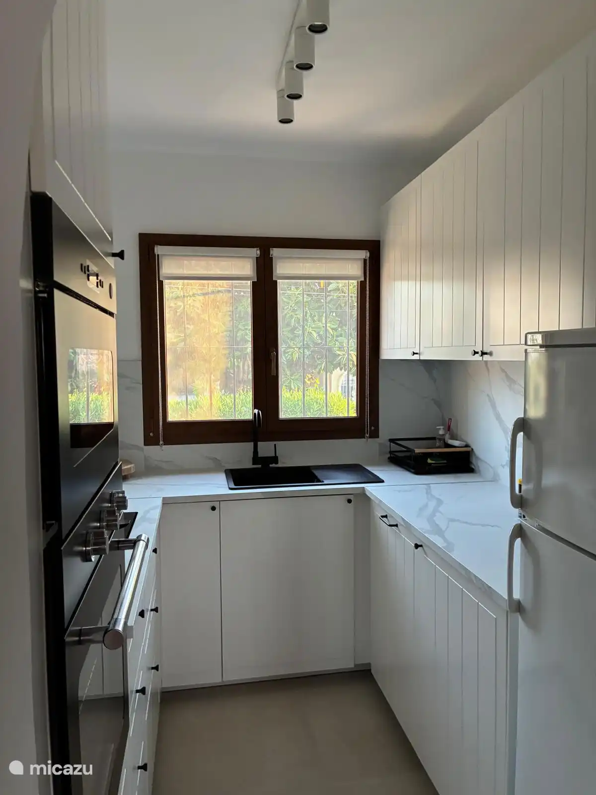 Benedenverdieping: volledig ingerichte keuken met koelkast, diepvries, oven, inductievuur, microgolfoven, koffiemachine en broodrooster