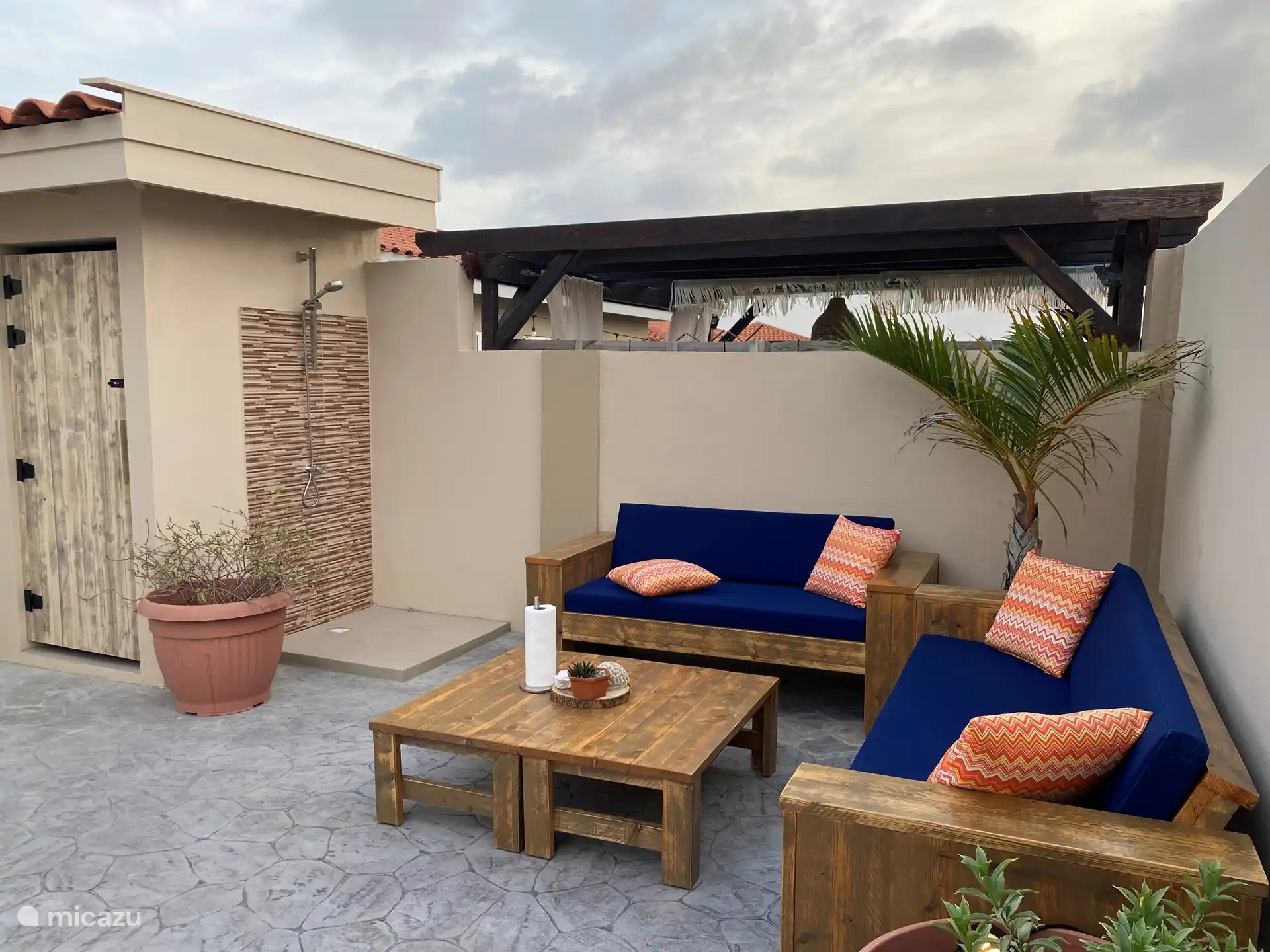 Coin détente avec toilettes extérieures et douche.