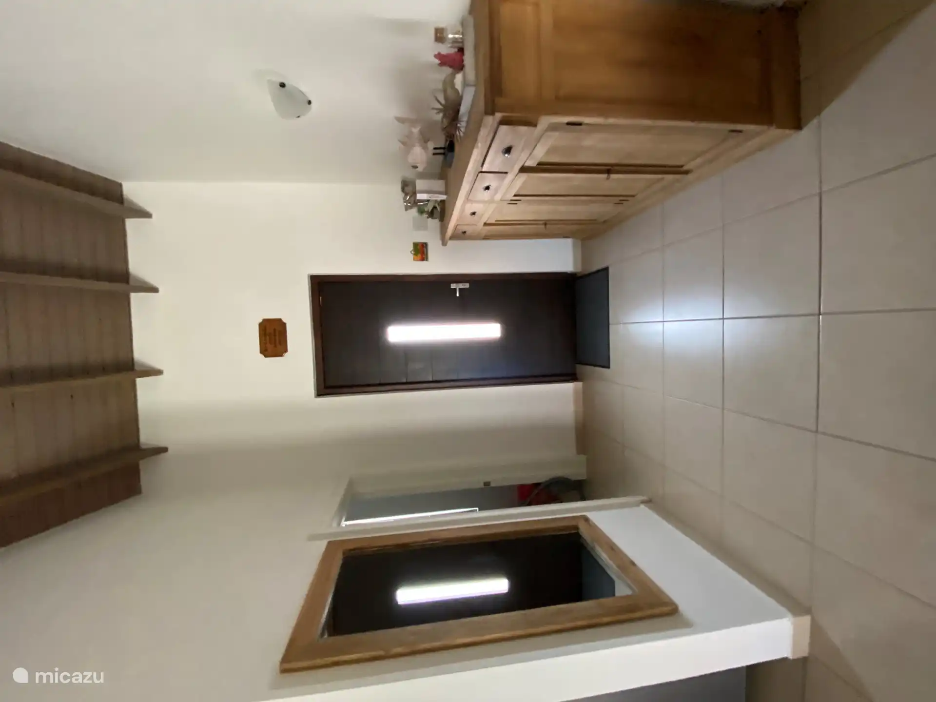 Maison d’entrée vers salon et cuisine ouverte.