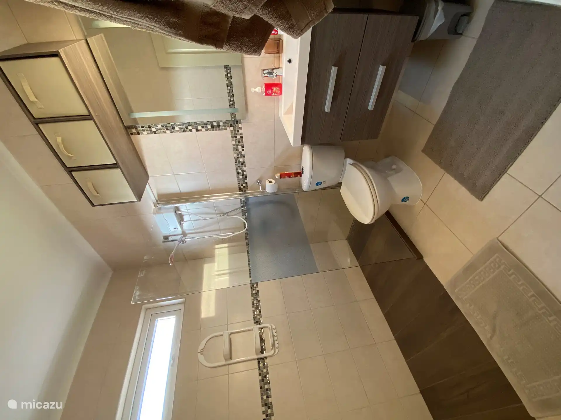 Grande salle de bain avec douche à l’italienne (eau chaude) et lavabo au milieu de la maison.